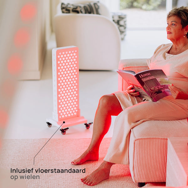 Vrouw leest in een fauteuil naast de Liroma Advanced Gen5 op de meegeleverde vloerstandaard op wielen